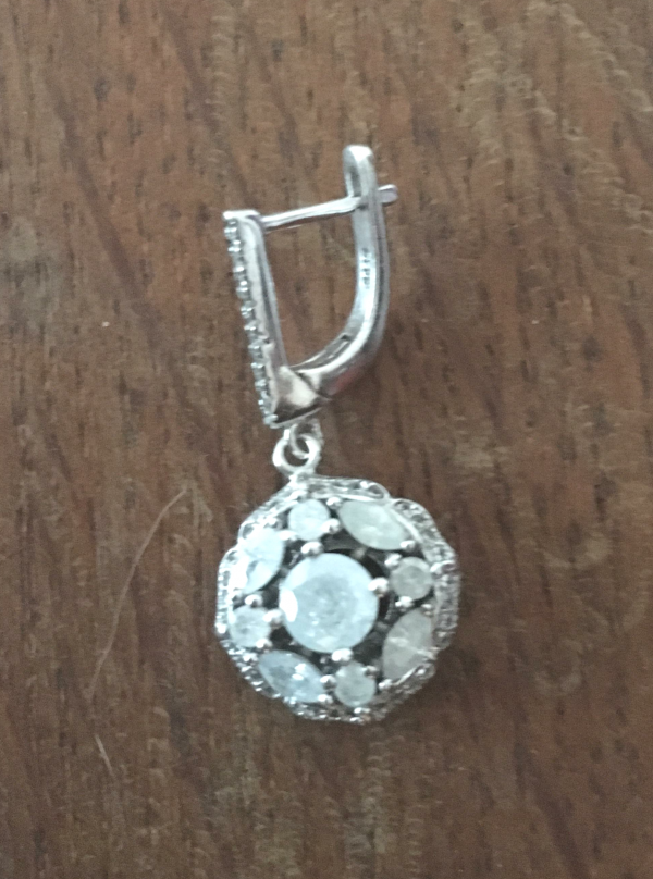 Une boucle d'oreille en argent et pierres bleues pâle