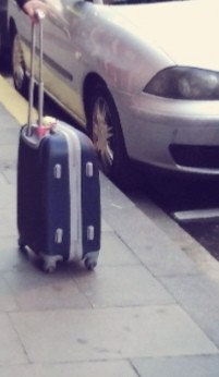 VALISE BLEUE REMPLIE DE VETEMENTS ET PAIRE DE CHAUSSURES NOIRES