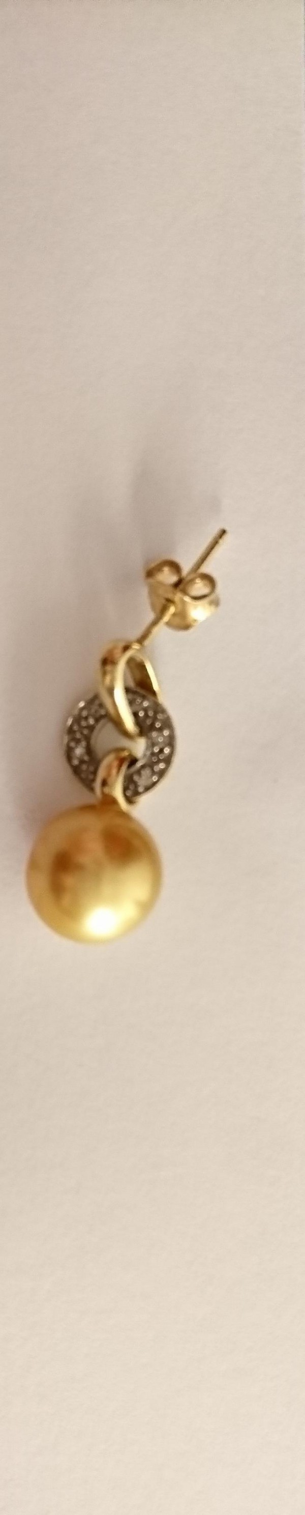 Une boucle d'oreille en or avec cercle de petits diamands et vraie perle de culture dorée. Rue Amiral Courbet,, Rue de l'Impératrice ou parking Carrefour à Berck