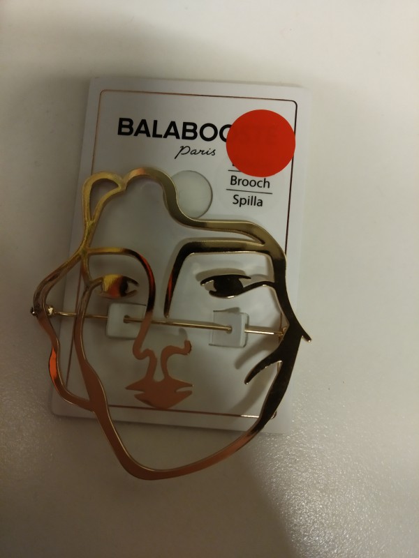 Broche dorée représentant un visage