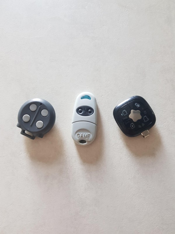 Trousseau de clés, télécommande grise, télécommande Ronde grise avec 4 boutons, une clé avec un cache bleu, le tout avec un cordon siglé PORSCHE