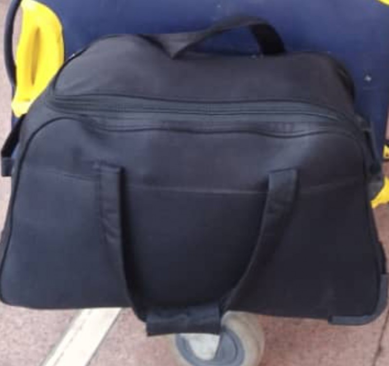 Une petite valise noir a roulette et poignet a la gare saint charles Marseille