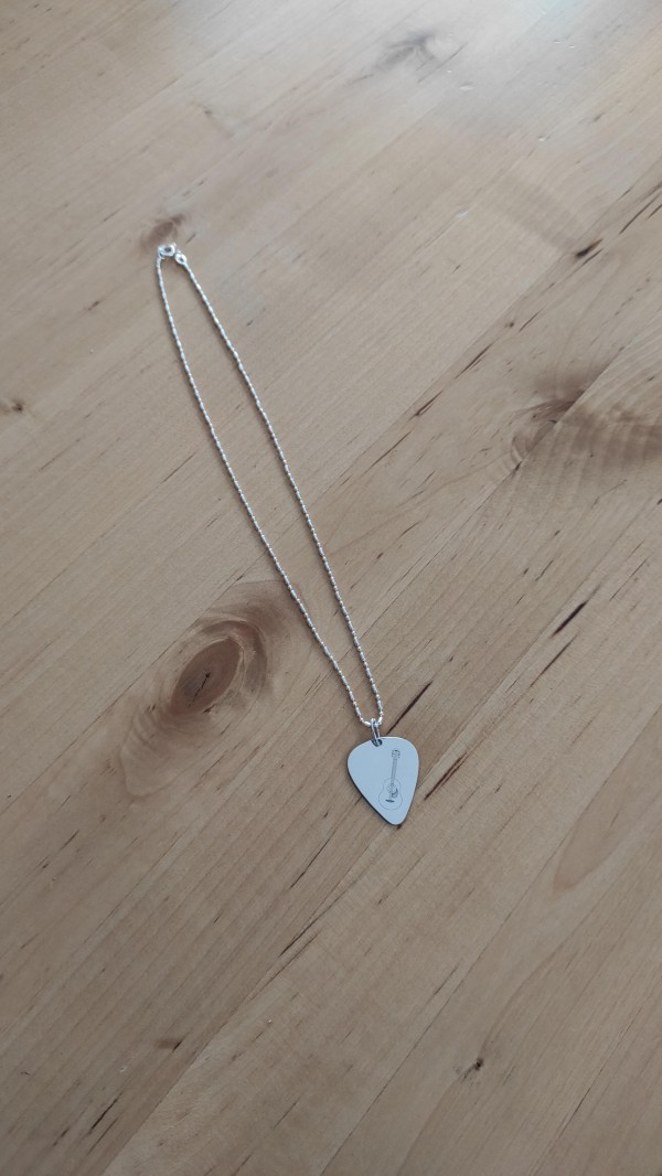 Perdu chaine avec médaillon en argent en forme de médiator comportant une gravure en forme de guitare + des lunettes de soleil adolescent bleues de marque Julbo neuves