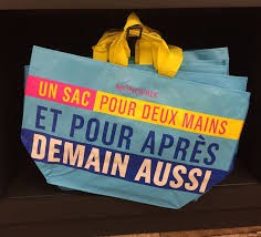 sac monoprix bleu (avec les écritures couverts de jaunes et rouges)