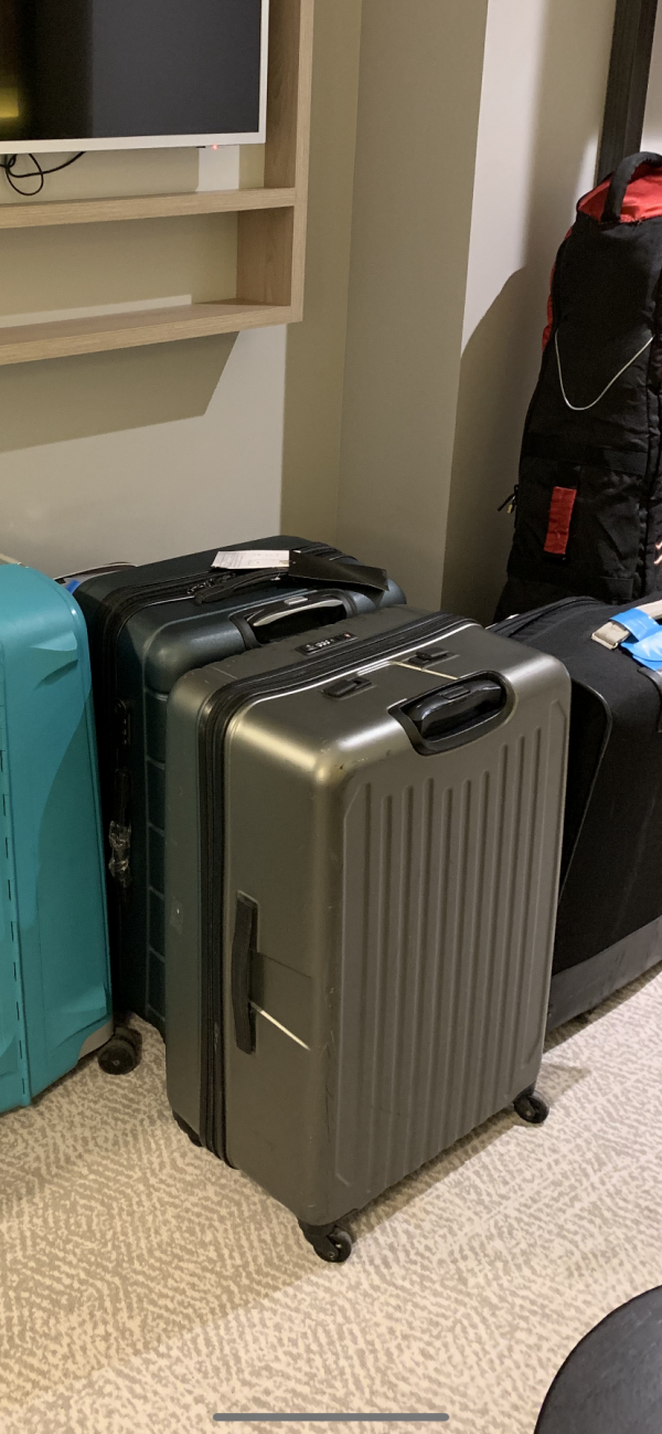Valise Grise plastique rigide classe madras air caraibes avec hansse du haut cassée.
