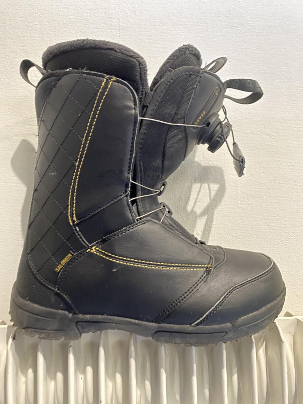 Une chaussure noire de snowboard marque Salomon au pieds des pistes de Morzine route d’Avoriaz.