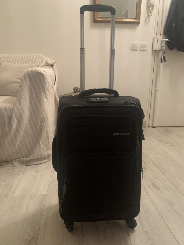 Valise noire à roulettes marque « prominent » dans train
