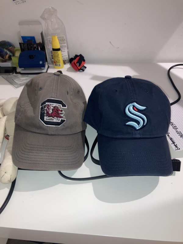 Casquette bleue marine avec un S bleu claire stylisé perdu sur la plage